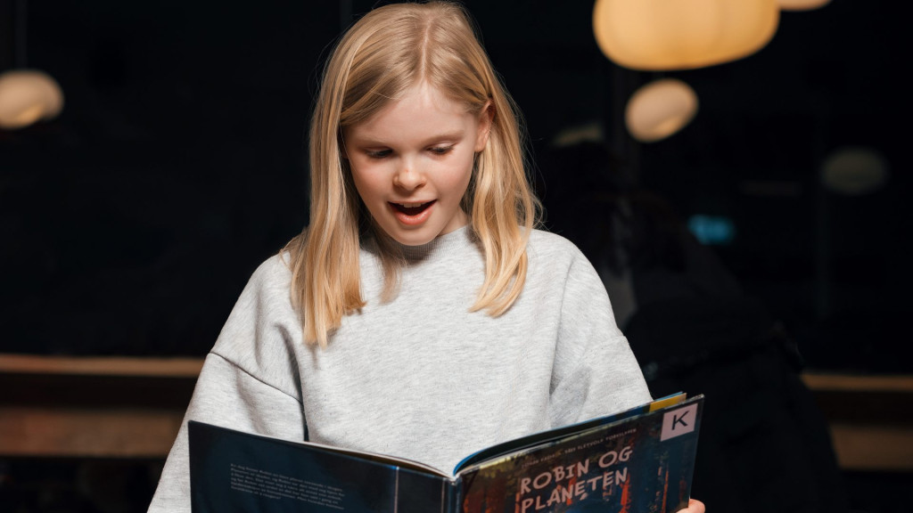 Kampanjebilde jente leser bok