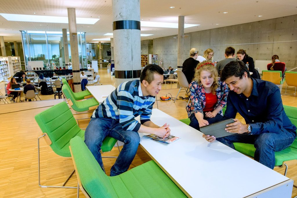 Illustrasjons bilde av studenter som arbeider på biblioteket ved Høgskolen i Østfold. 