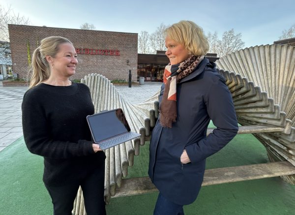Bilde av biblioteksjef Trine O. Schøning og Else M Andersen. Står utenfor biblioteket med en I-pas
