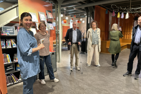 Representantskapet besøker Fredrikstad bibliotek. Tre medlemmer fra representantskapet, fylkesbiblioteksjefen, biblioteksjef i Fredrikstad og bibliotekansatt i Fredrikstad står i halvsirkel og ser mot kamera.