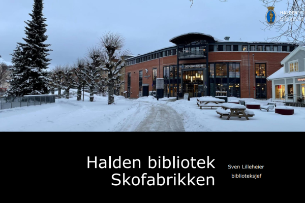 Bildet av Halden biblioteks bygg Skofabrikken. Mur bygning med store vinduer og Interoptik i bygget ved siden av. Snødekt bakke, trær og benker foran byggene.