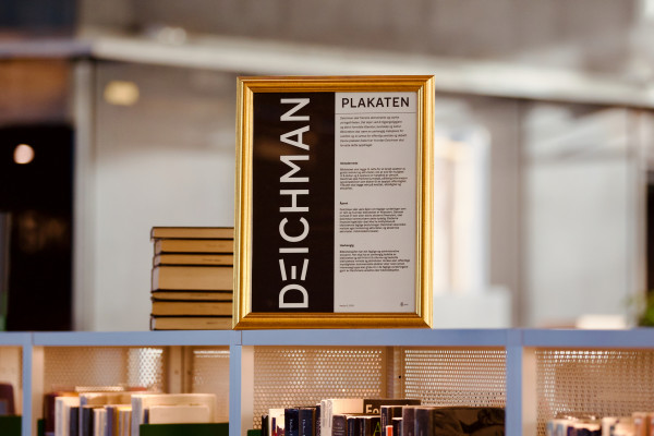 innrammet plakat står oppå en hylle i biblioteket