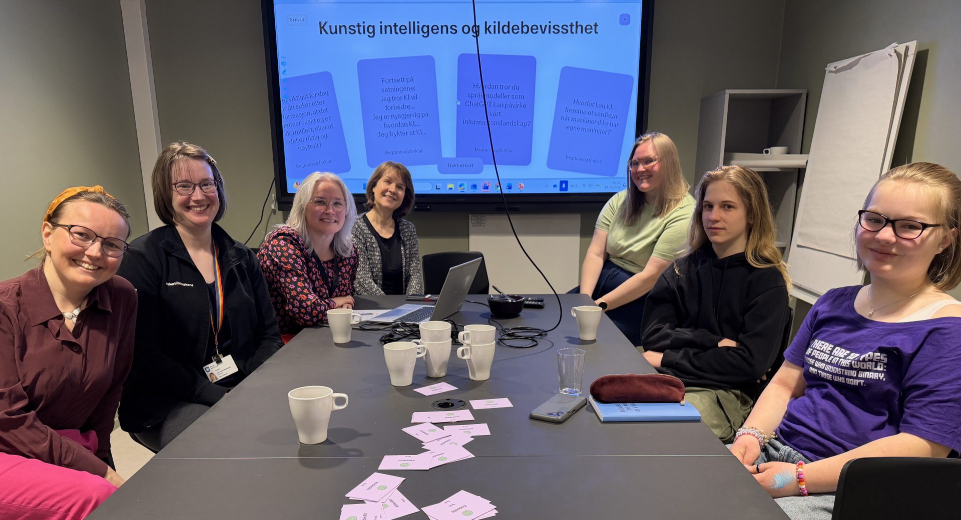 Bilde av personer som sitter rundt et bord og snakker om digital kildebevissthet.